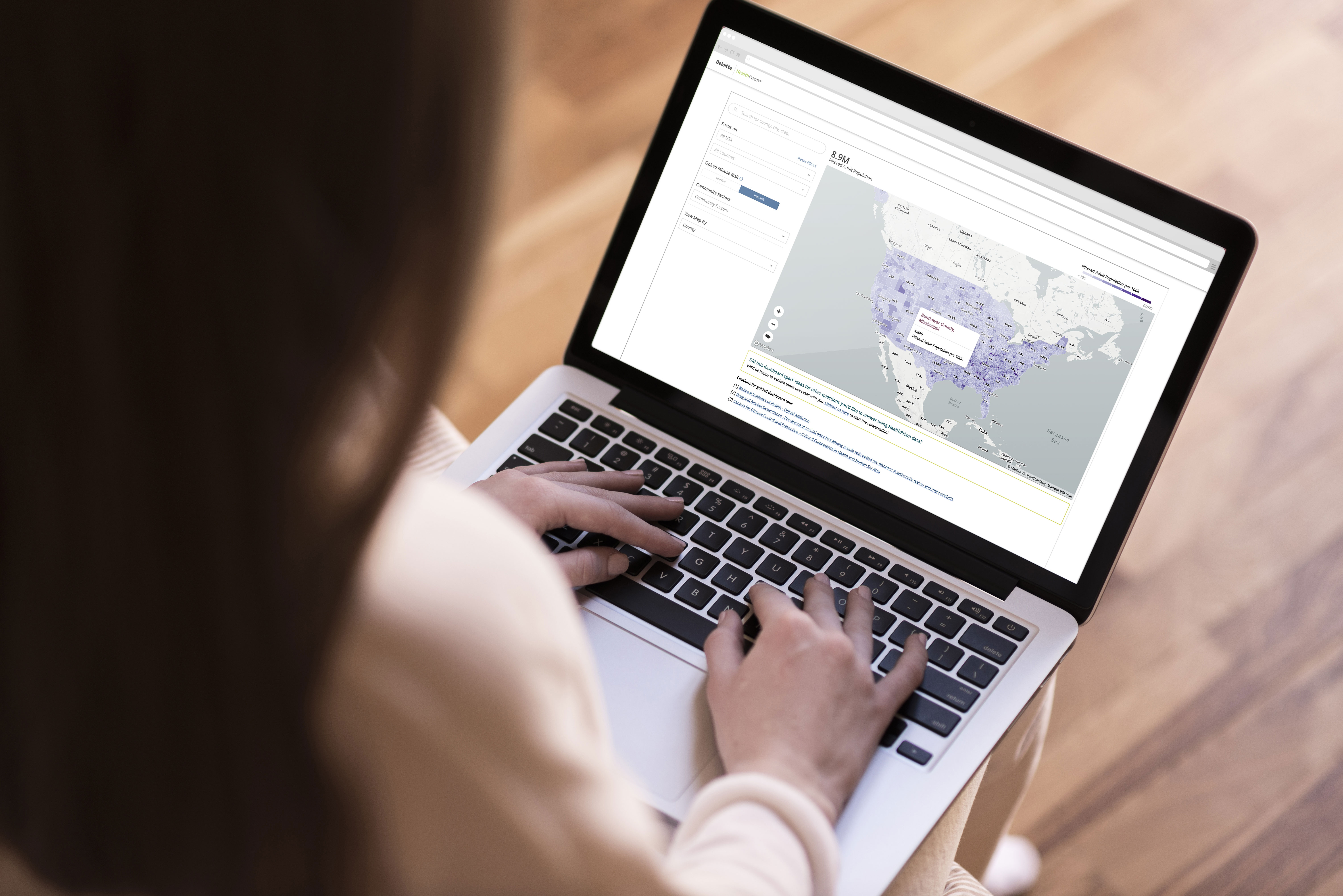 HealthPrism analytics platform displayed on a laptop with health outcome data